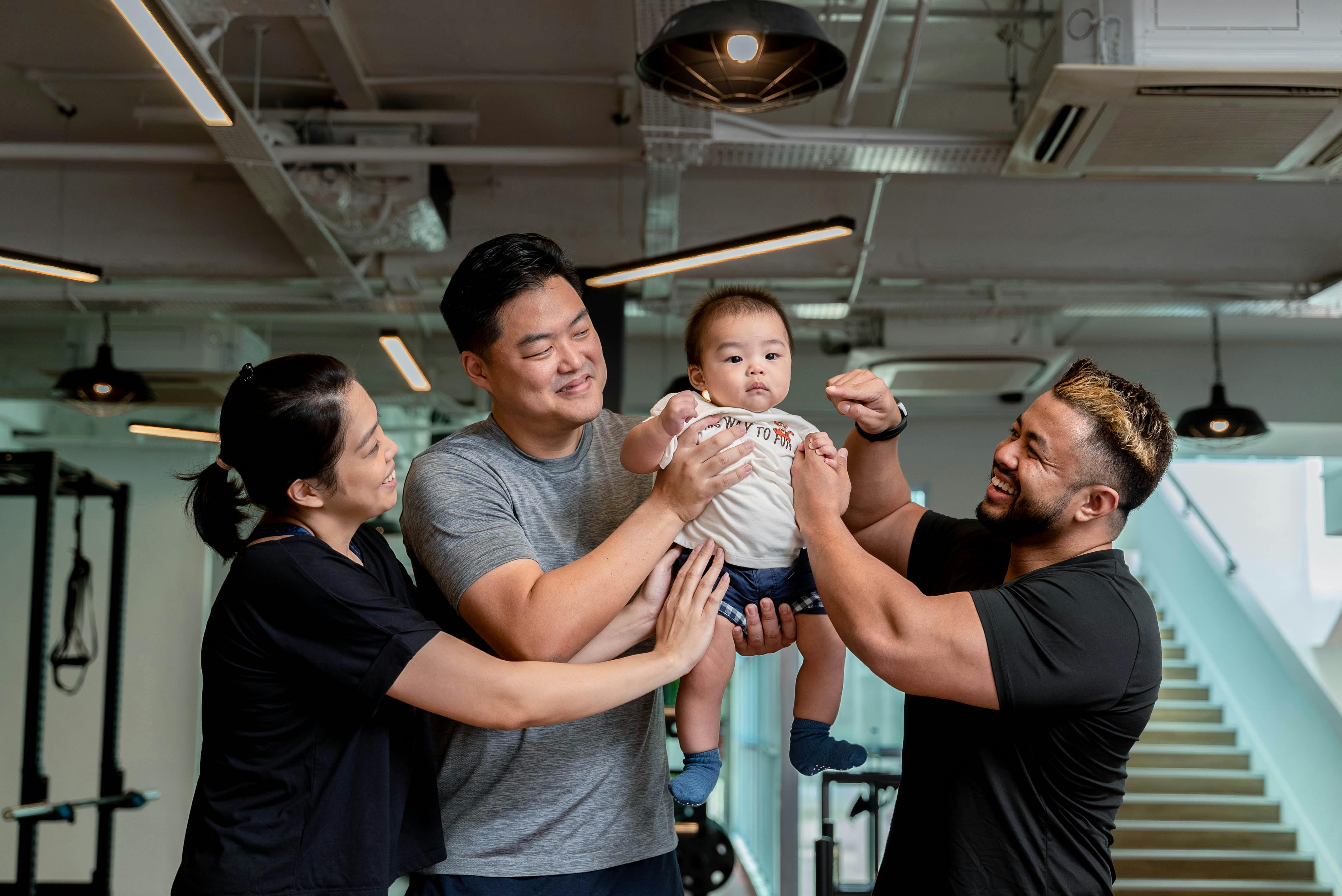 Happy family with baby in modern gym setting